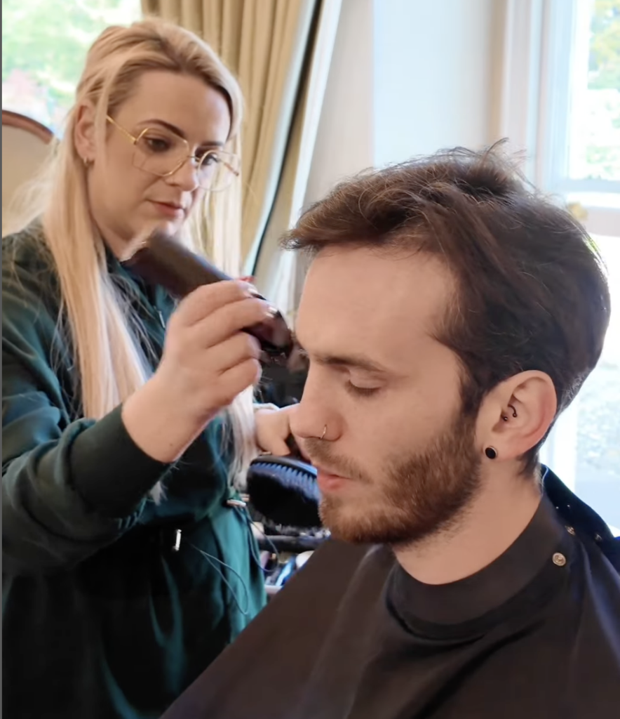 Claire from Groom the Groom NI tidying her client's hair on the morning of the wedding